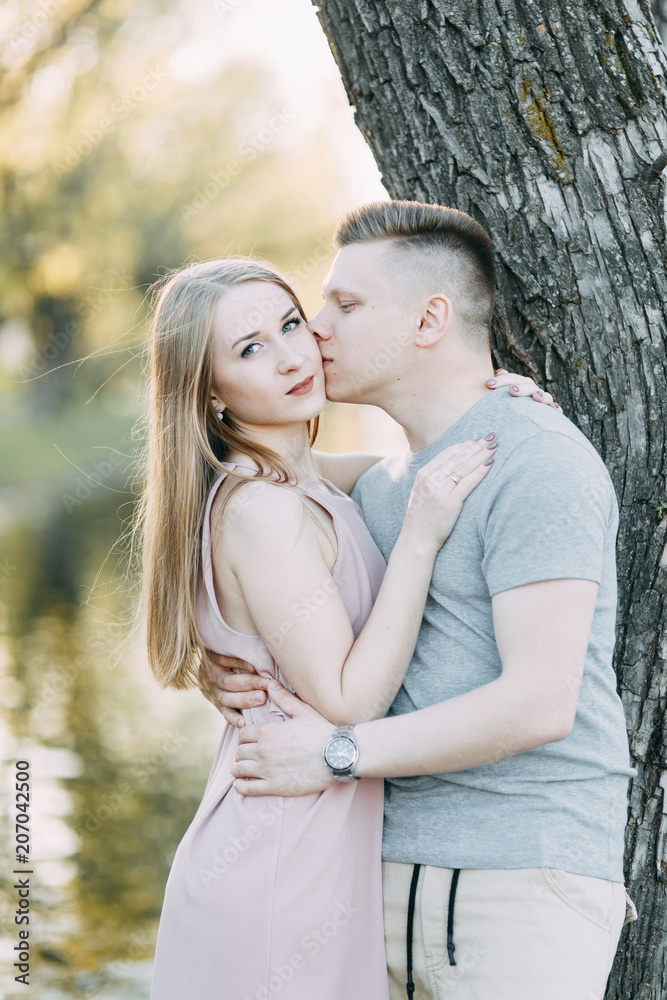 Beautiful young couple in the Park on a Sunny day, loving and happy. Walk and laugh. Pre-wedding shooting in nature. Casual style in clothing and European in processing Beautiful young couple in the Park on a Sunny day, loving and happy. Walk and laugh. Pre-wedding shooting in nature. Casual style in clothing and European in processing