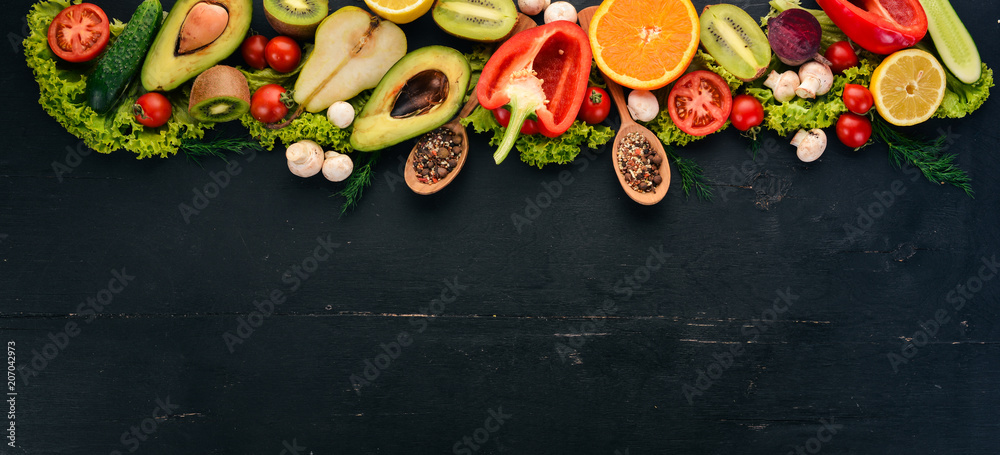 Healthy food. Vegetables and fruits On a black wooden background. Top view. Copy space.