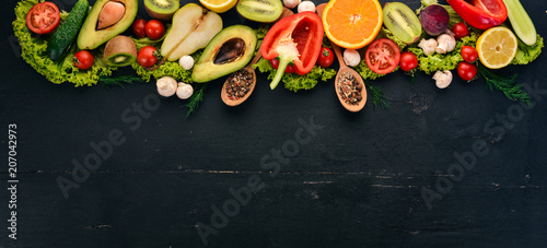 Healthy food. Vegetables and fruits On a black wooden background. Top view. Copy space.