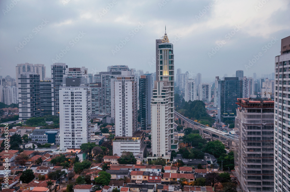 View of the city skyline in the early morning light with houses and buildings under cloudy skies in the city of São Paulo. The gigantic city, famous for its cultural and business vocation.