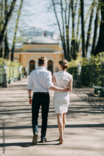 Beautiful young couple in the Park on a Sunny day, loving and happy. Walk and laugh together. Pre-wedding shooting in nature. Elegant style in clothes like celebrities © pavelvozmischev