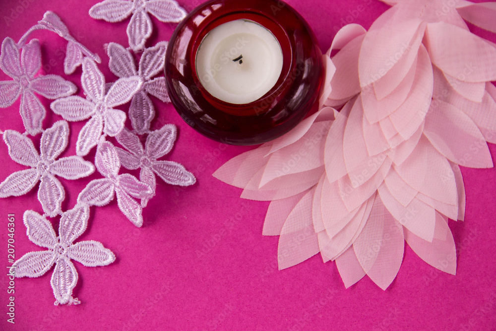 On a pink background azhurnre lace and a candle On a pink background azhurnre lace and a candle
