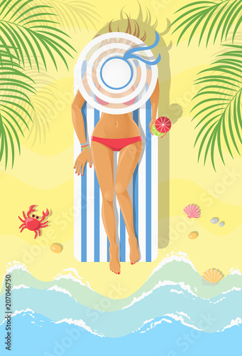 Sunbathing young woman on a chaise-longue on a beach