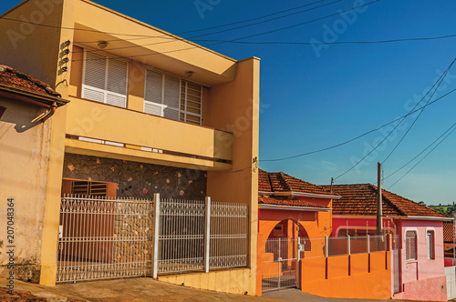 Working-class colored houses and fences in an empty street at São Manuel. A cute little town in the countryside of São Paulo State. Southeast Brazil. Retouched photo. photo