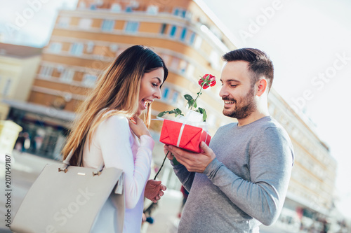 Man surprises woman with a gift and rose in the city