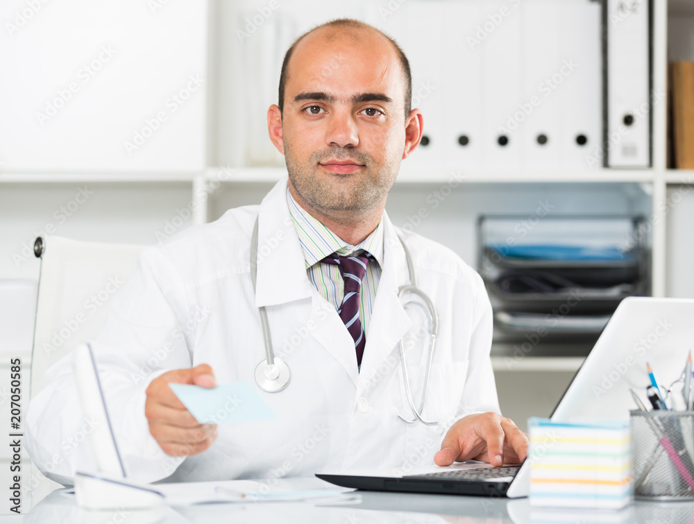 Fototapeta premium Smiling therapist in uniform filling up documents