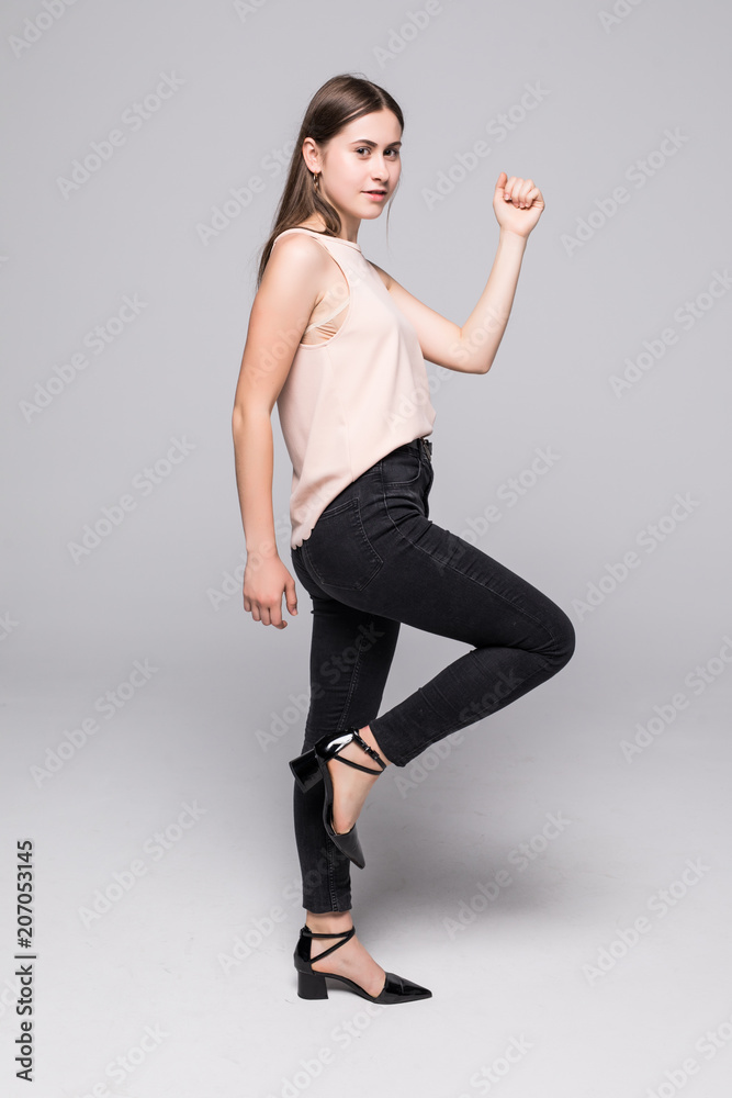 side view of a casual young woman walking away from the camera and smiling on white background side view of a casual young woman walking away from the camera and smiling on white background