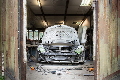 white broken assorted dusty car stands in the garage