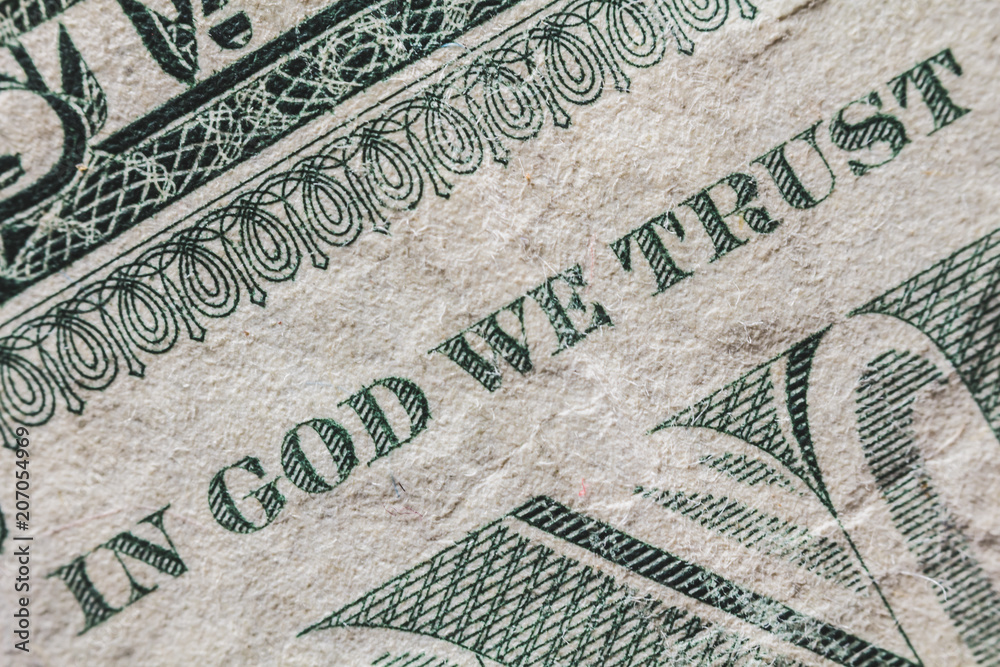 A detail of a one dollar bill. We can read the famous sentence "in god