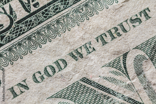 A detail of a one dollar bill. We can read the famous sentence 