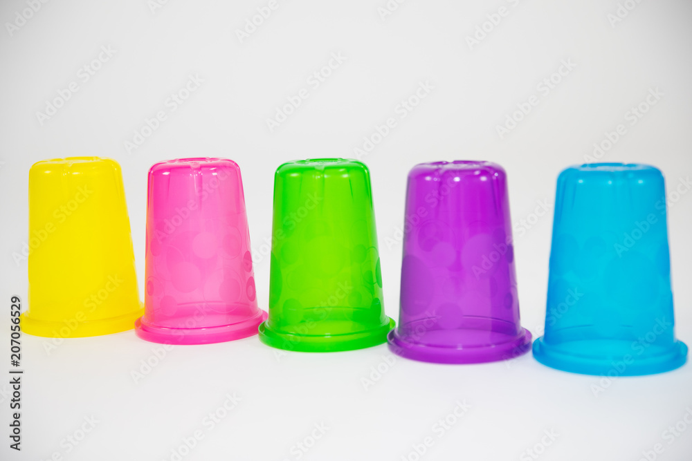 colorful plastic cups of lemonade on a white background. utensils for a picnic and travel colorful plastic cups of lemonade on a white background. utensils for a picnic and travel