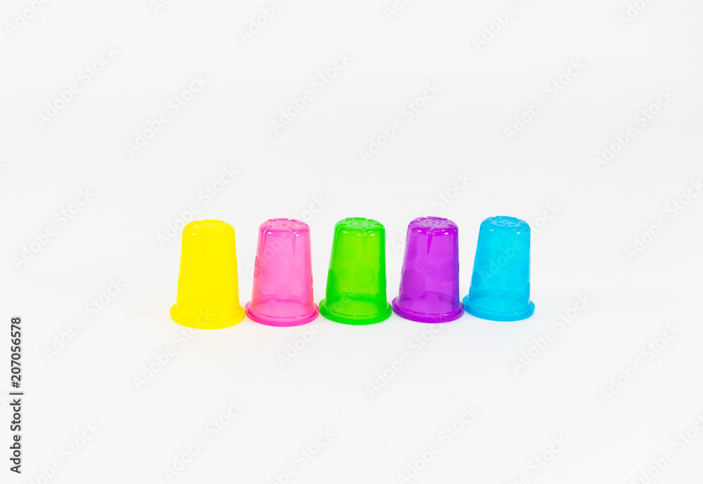 colorful plastic cups of lemonade on a white background. utensils for a picnic and travel colorful plastic cups of lemonade on a white background. utensils for a picnic and travel