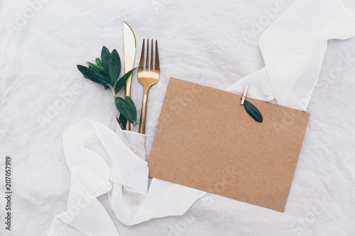 Kraft invitation card with cutlery. Wedding template dinner concept. Top view photo