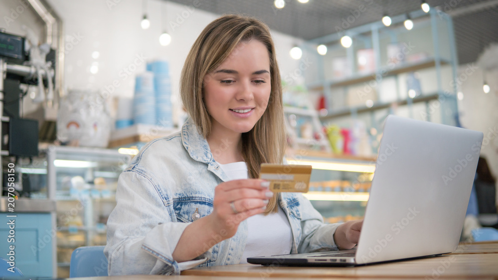 Happy blonde woman make online purchasing using laptop computer and credit card Happy blonde woman make online purchasing using laptop computer and credit card