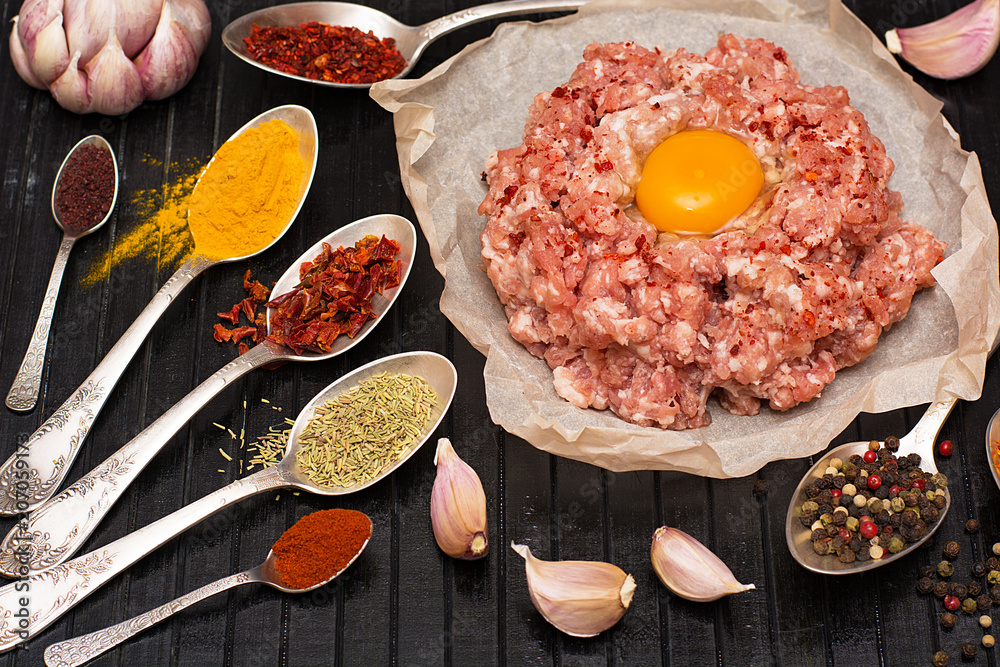 Minced meat. Ground meat with ingredients for cooking on a black background. Minced meat. Ground meat with ingredients for cooking on a black background.