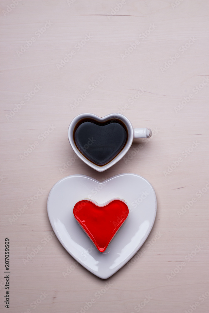 Fototapeta premium Heart shaped coffee cup and cake on wood surface