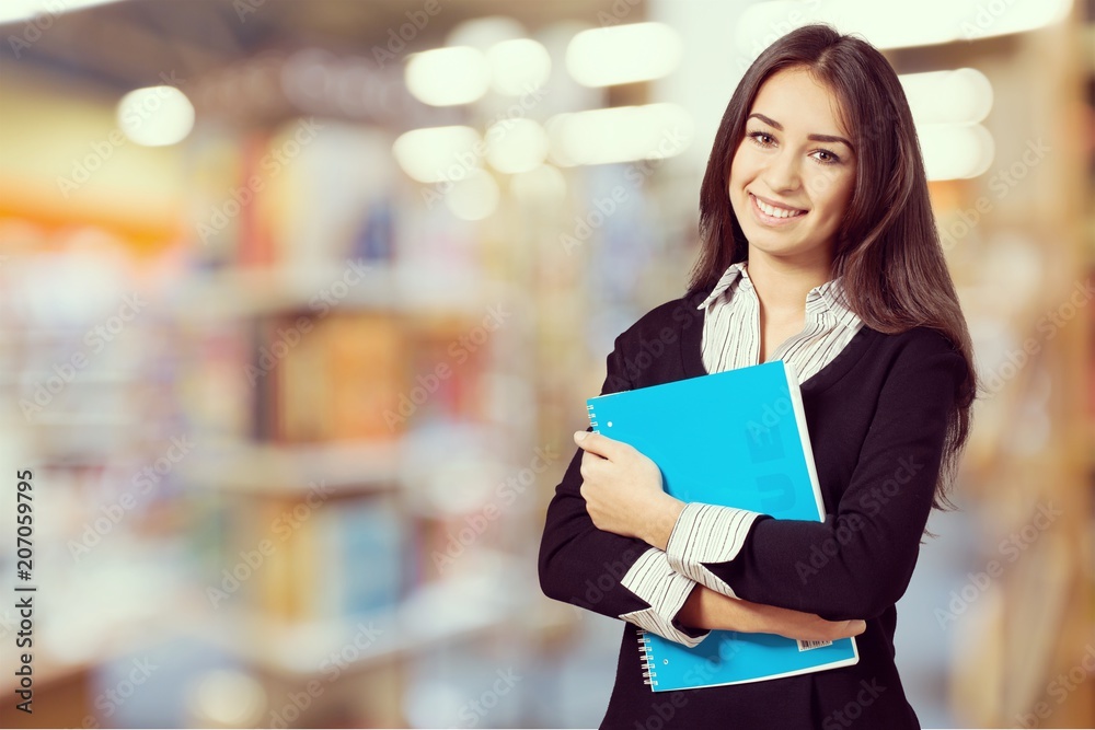 Young smiling woman holding blue notebook Young smiling woman holding blue notebook