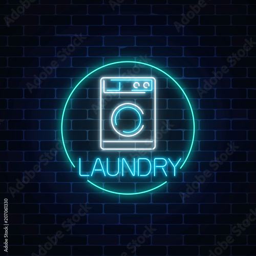 Neon glowing laundry signboard in circle frame. Illuminated self-service washhouse sign working round-the-clock.