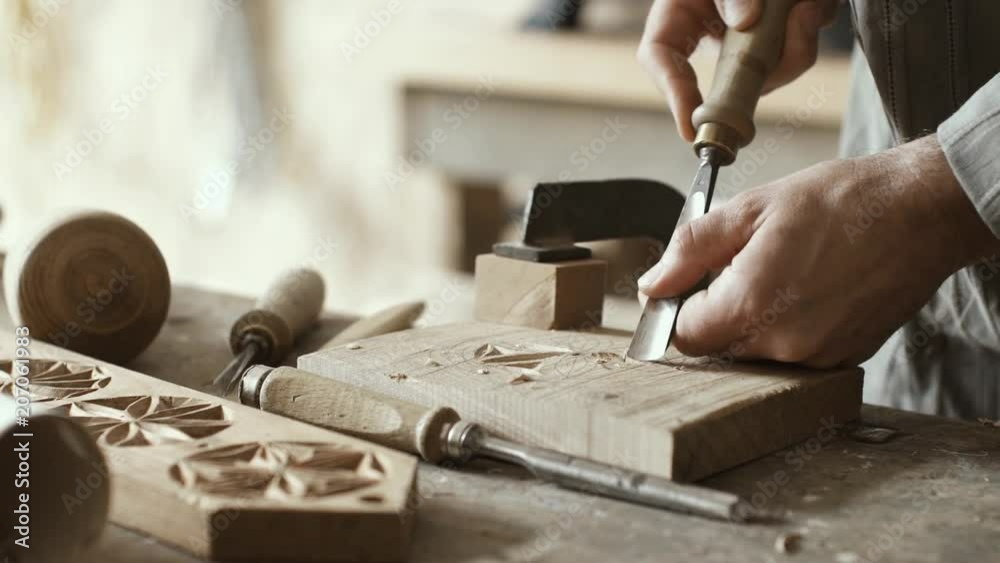 Professional carpenter carving wood using a gouge