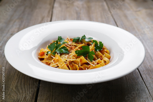 Pasta Fettuccine Bolognese in tomato sauce with chicken and parsley. Traditional Italian cuisine, delicious food, restaurant menu concept photo