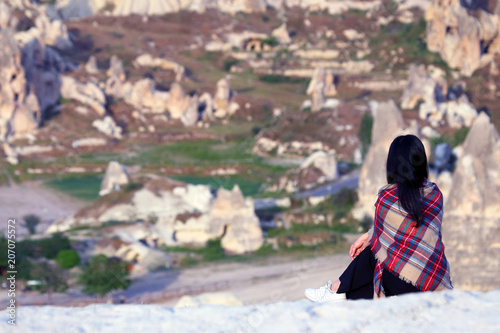 Fototapeta Naklejka Na Ścianę i Meble -  girl from a hill looks at the volcanic rocks in the valley of Cappadocia, Turkey