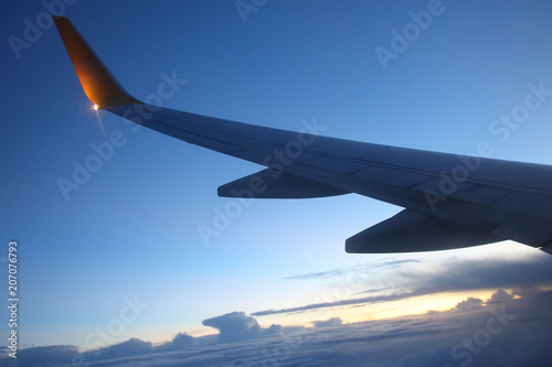 Wing passenger aircraft in flight over the evening clouds