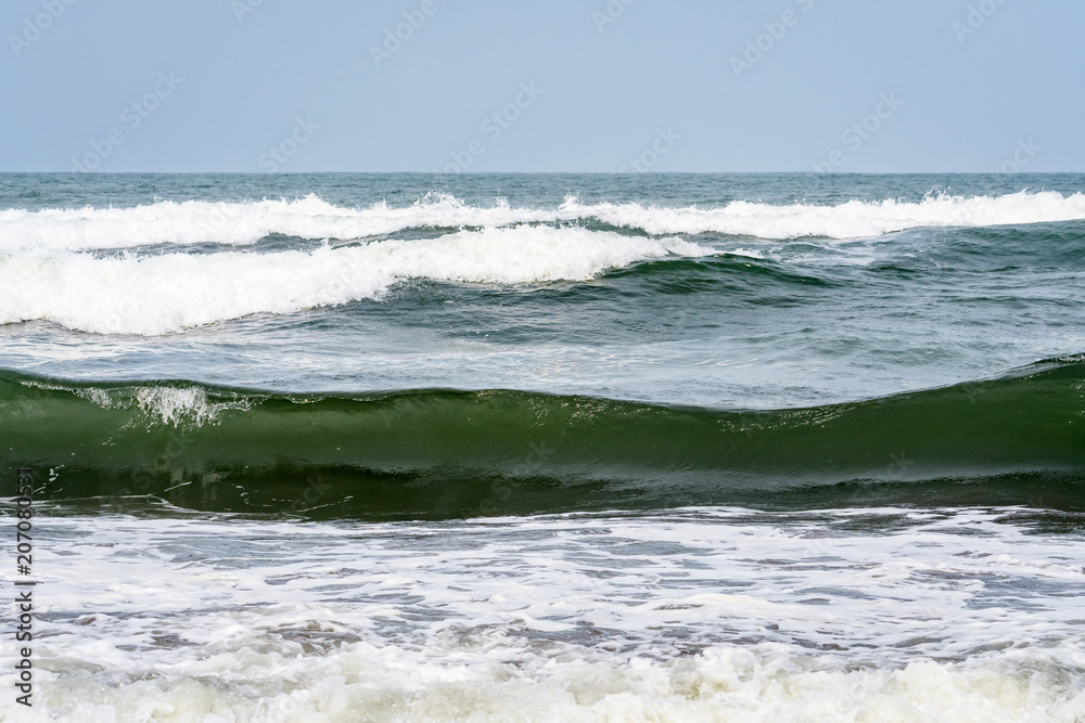 Waves breaking on the Caribbean Sea with blue sky in the background, as a nature background
