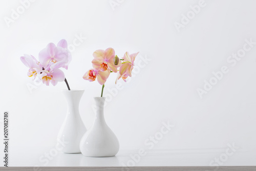 Fototapeta Naklejka Na Ścianę i Meble -  beautiful orchids in white vase on white table