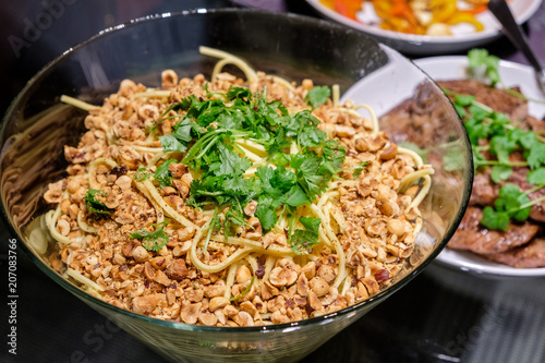 Dry spaghetti noodles with ground nuts and parsley in bowl