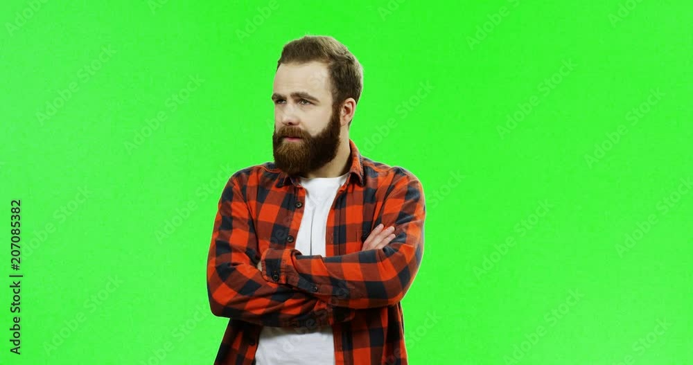 Portrait of the angry offended Caucasian man with a beard standing in front of the camera and doing look into my eyes gesture, or eyes in eyes on the green screen background. Chroma key. Portrait of the angry offended Caucasian man with a beard standing in front of the camera and doing look into my eyes gesture, or eyes in eyes on the green screen background. Chroma key.