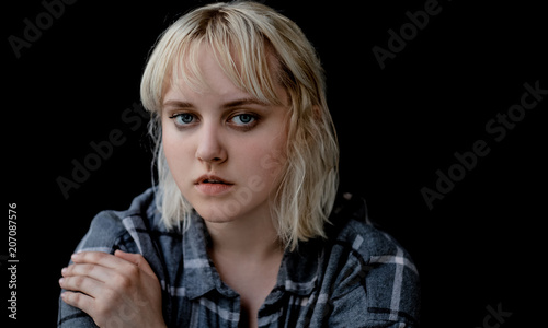 Close up of teenager with depression sitting alone in dark room. Sadness, nostlagic, depression. Problems of young people.