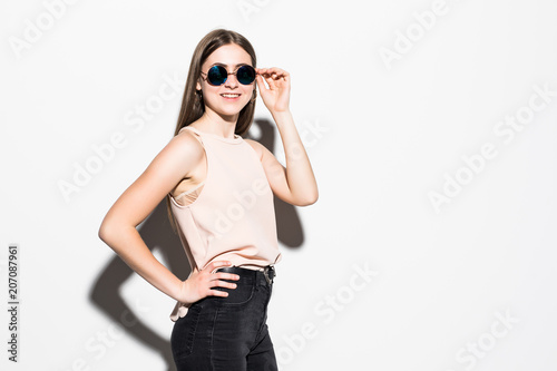 Young fancy woman holding sunglasses isolated on white background