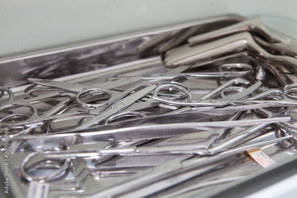 Medical scissors, tweezers and other tools in a stainless steel tray Medical scissors, tweezers and other tools in a stainless steel tray