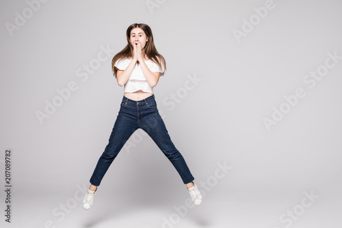 happiness, freedom, motion and people concept. Smiling young woman jumping in air over white background