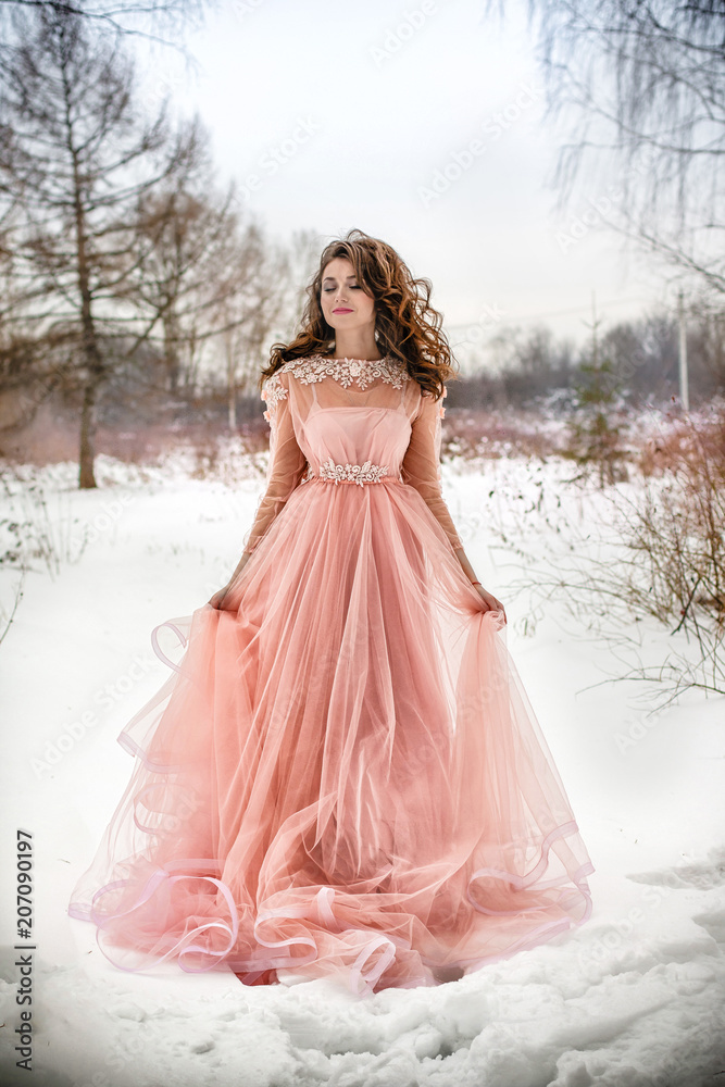 Girl in a beautiful pink dress in a winter forest Girl in a beautiful pink dress in a winter forest