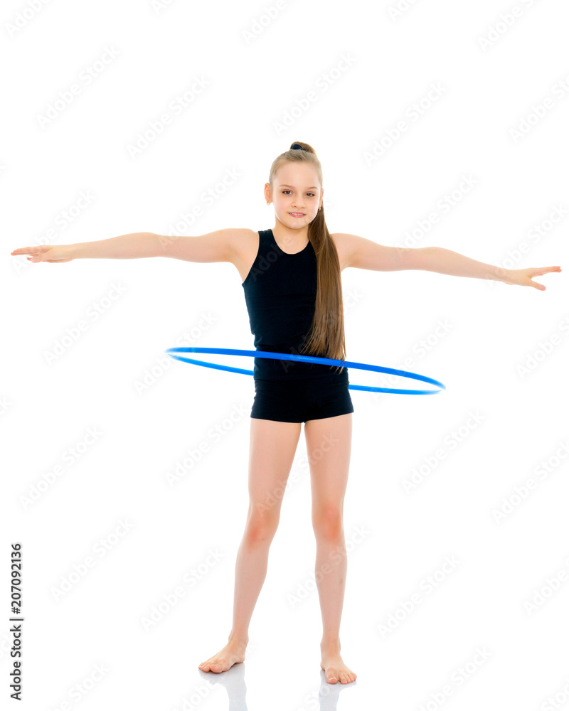 A girl gymnast performs an exercise with a hoop. A girl gymnast performs an exercise with a hoop.
