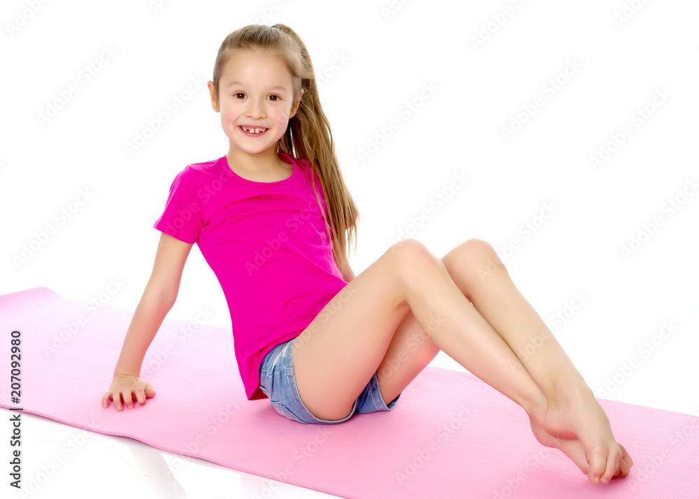 The little gymnast perform an acrobatic element on the floor. The little gymnast perform an acrobatic element on the floor.