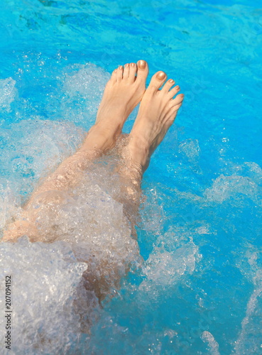 legs of a lady who relaxes in the hot tub