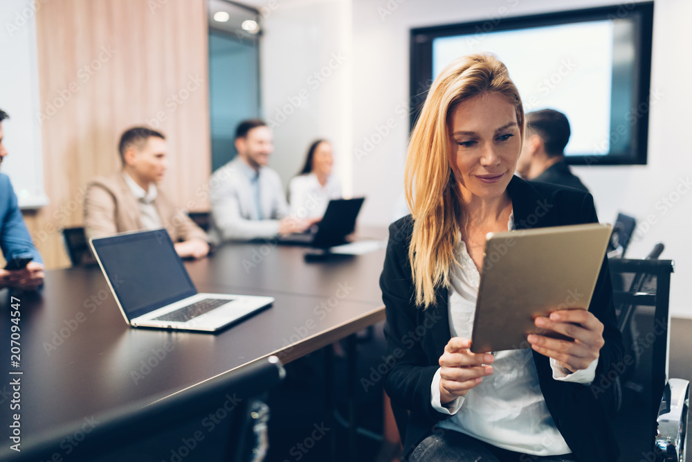 Attractive businesswoman using digital tablet in office Attractive businesswoman using digital tablet in office