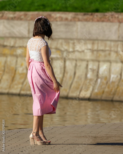 A girl in high heels near the embankment