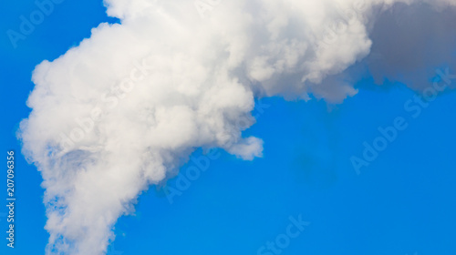 smoke from a pipe in the factory against a blue sky