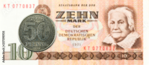 50 pfennig coin against historic 10 east german mark bank note photo