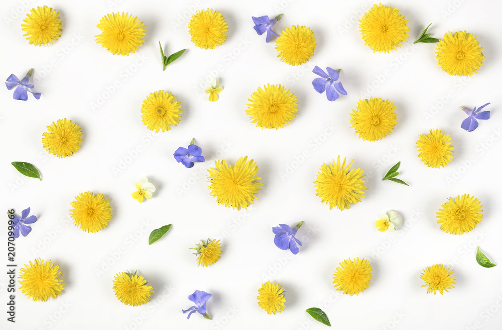 Obraz premium Floral pattern made of yellow dandelion, lilac flowers and leaves isolated on white background. Flat lay. Top view.