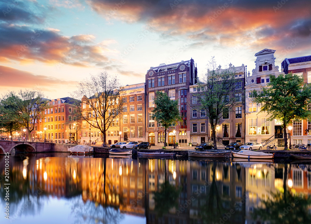 Naklejka premium Domy nad kanałem amsterdamskim na zachodzie słońca, Holandia