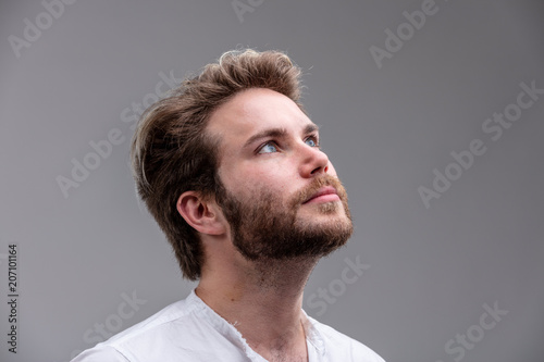Young man looking up while thinking of a new idea