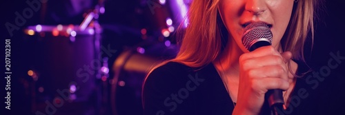 Portrait of female singer performing with male drummer photo