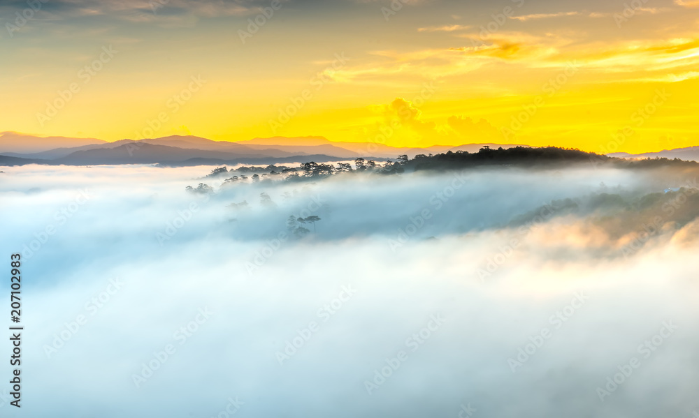 Dawn on plateau in morning with colorful sky, while sun rising from horizon shines down to small village covered with fog shrouded  landscape so beautiful idyllic countryside Dalat plateau, Vietnam