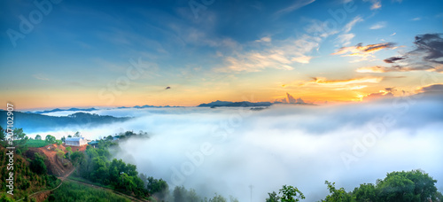 Fototapeta Naklejka Na Ścianę i Meble -  Dawn on plateau in morning with colorful sky, while sun rising from horizon shines down to small village covered with fog shrouded  landscape so beautiful idyllic countryside Dalat plateau, Vietnam