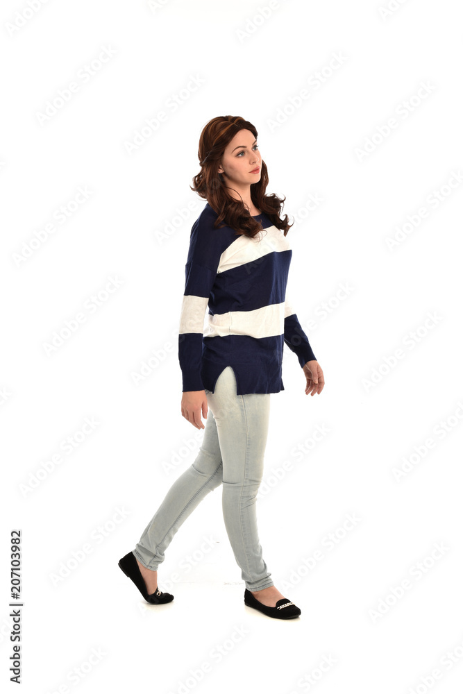 full length portrait of girl wearing striped blue and white jumper and jeans. standing pose on white studio background full length portrait of girl wearing striped blue and white jumper and jeans. standing pose on white studio background