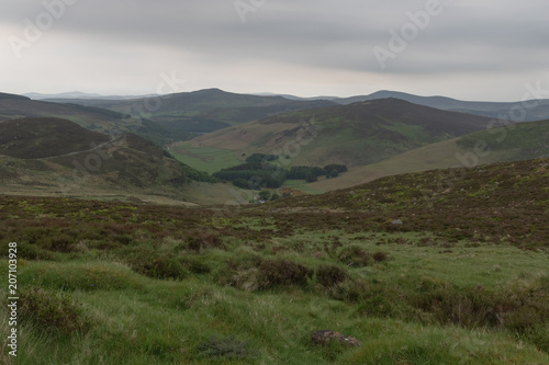 Mountain range disappearing into horizon, dramatic sky, lake, summertime